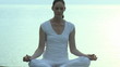 Woman doing Yoga with the sea in the background