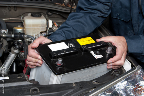 Photo: Auto mechanic replacing car battery Auto mechanic replacing car battery