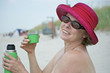 Photo: Frau am Strand sitzend mit grüner geöffneter Thermoskanne Frau am Strand sitzend mit grüner geöffneter Thermoskanne