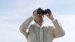 Businessman outside watching via binoculars