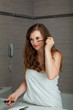 dressed in towel gorgeous woman makeup at modern bathroom