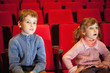 boy and  little girl sitting on armchairs at cinema