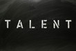 The word TALENT in stencil letters on a blackboard