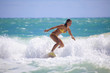 teenage girl in a yellow bikini surfing in Hawaii teenage girl in a yellow bikini surfing in Hawaii