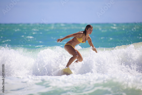 Photo: teenage girl in a yellow bikini surfing in Hawaii teenage girl in a yellow bikini surfing in Hawaii