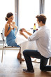 Young man proposing with an engagement ring to his girlfriend in