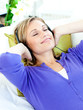 Relaxed caucasian woman listening to music with headphones lying