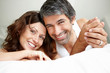 Relaxed mature couple lying on bed smiling Relaxed mature couple lying on bed smiling