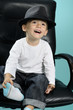 playful caucasian child smiling and showing black hat