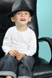 beautiful little boy smiling and sitting on chair
