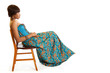 Serious young black woman sitting on chair