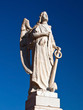 Marble angel statue with a bright blue sky in a cementry
