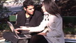 Video: two hispanic students using laptop sitting in a park in France two hispanic students using laptop sitting in a park in France
