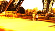 An orange fast moving Crowd Underneath the Eiffel Tower