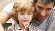 son and father making soap bubbles in the garden