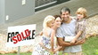 young family in front of their new house