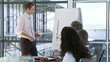 young businessman giving presentation with blackboard and graphs