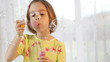 Little girl blows soap bubble