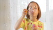 Little girl blows soap bubble