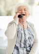 Happy senior woman laughing over telephone