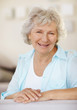 Happy senior woman smiling against blurred background