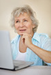 Thoughtful senior woman working on a laptop
