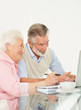Old couple working on laptop at home