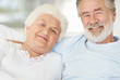 Happy senior couple sitting together at home