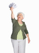 Happy mature woman holding dollars isolated against white