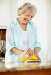 Happy mature woman with having her breakfast at kitchen