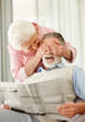 A mature woman covering a senior man's eyes to surprise him