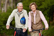Happy matured couple walking with bicycle in countryside