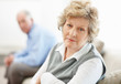 Serious mature female sitting with a man in background