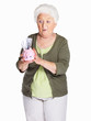 Surprise mature woman holding piggy bank isolated on white