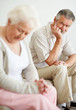 Tensed mature man looking at a sad senior woman