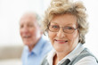 Beautiful senior female with a blurred mature man in background
