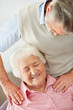 Mature female receiving shoulder massage from a senior man
