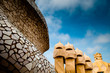 close-up roof top shot of Gaudi's Casa Milà building with blue s