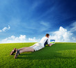 Young man use a notebook on green field
