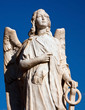 Marble angel statue with a bright blue sky in a cementry