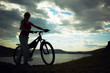 Silhouette of the girl with a bicycle against mountains Silhouette of the girl with a bicycle against mountains