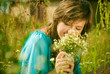 beautiful girl sitting in a field with a bouquet of flowers