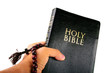 bible with a rosary on a white background