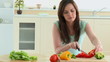 Concentrated woman cutting vegetables in her kitchen at home