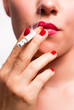 Mund mit roten Lippen und roten Fingernägeln beim Rauchen V1