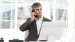 smiling manager on phone sitting in his officeq