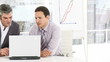 two business men woking at a laptop sitting in the office