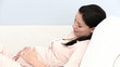 pregnant woman lying on her sofa at home