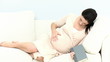Video: pregnant woman touching he belly lying on sofa pregnant woman touching he belly lying on sofa