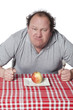 homme de mauvaise humeur devant une pomme de régime
